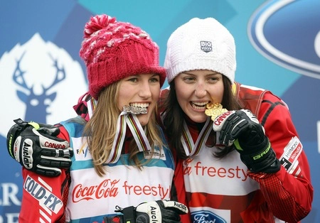 Two Olympic medal winners bite into their gold and silver medals, which is great for photo opportunities but a horrible means to test for fake gold.